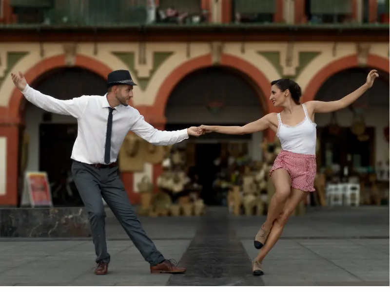 dance partners showing the style of swing dancing on the street